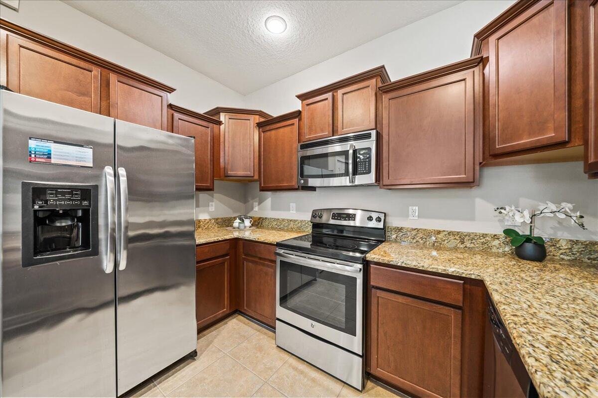 3795 Sansome Circle Melbourne, FL 32940 - Photo 9 of 76 a kitchen with stainless steel appliances granite countertop a stove microwave and cabinets