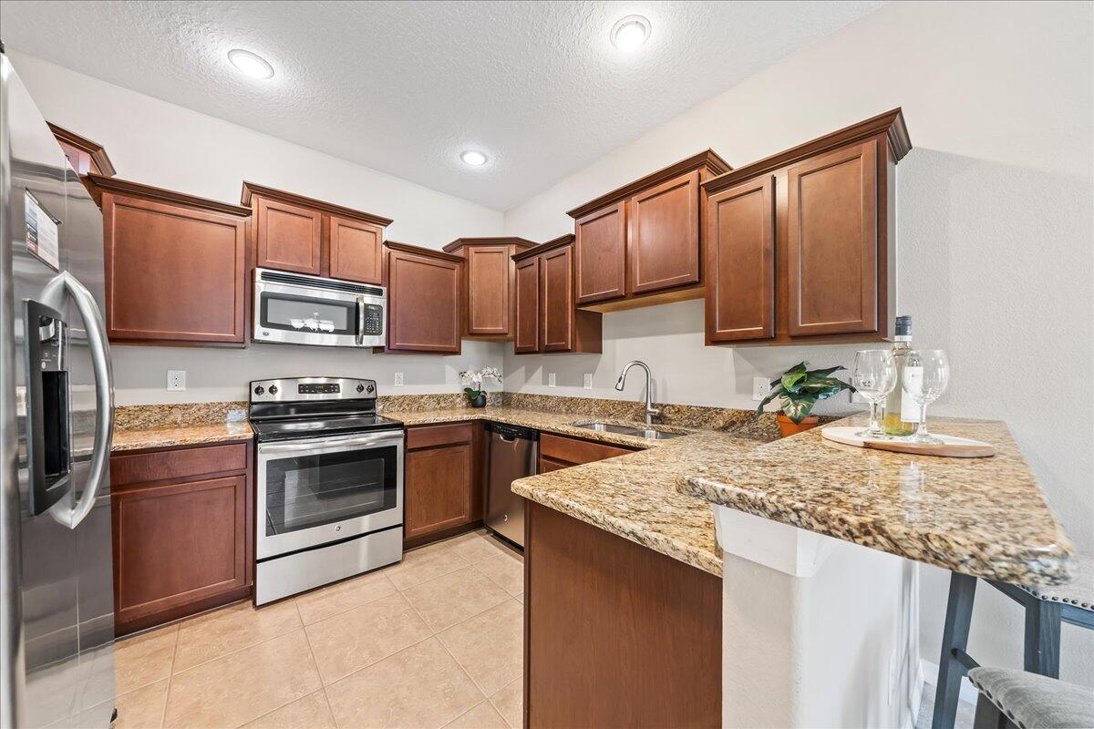 3795 Sansome Circle Melbourne, FL 32940 - Photo 10 of 76 a kitchen with kitchen island granite countertop a sink stove and cabinets