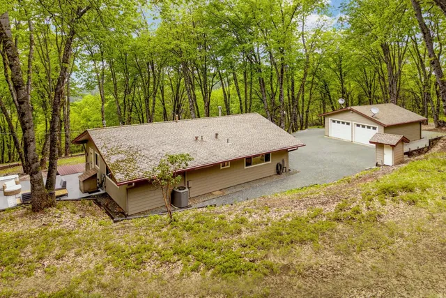 a small barn with a big yard and large trees