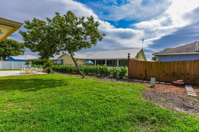 a view of a house with backyard and a tree