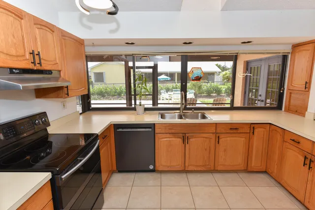 a kitchen with stainless steel appliances a stove a sink and a refrigerator with wooden floor