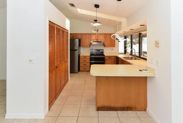 a view of a kitchen with stainless steel appliances granite countertop a sink and a granite counter tops