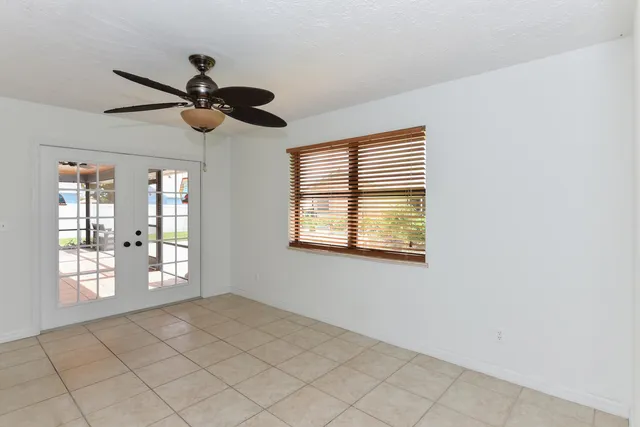 an empty room with windows and fan