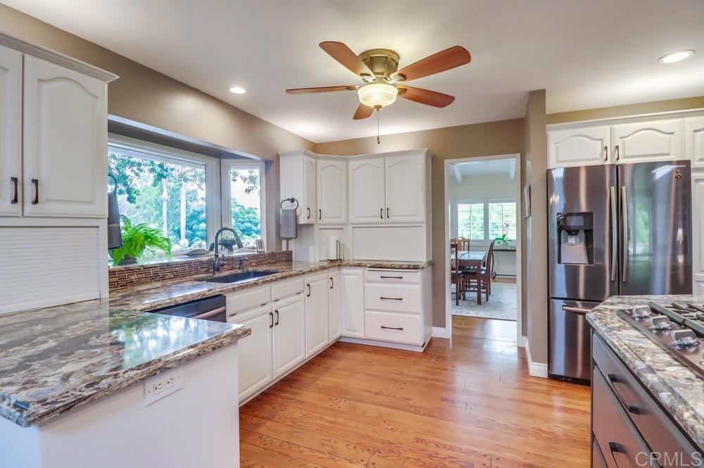 1601 Hidden Mesa Road El Cajon, CA 92019 - Photo 10 of 31 a kitchen with stainless steel appliances kitchen island granite countertop a refrigerator and a stove top oven