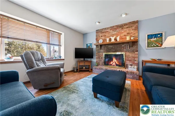 a living room with furniture a flat screen tv and a fireplace