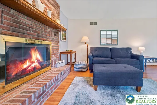 a living room with furniture a fireplace and a flat screen tv
