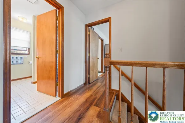 a view of a hallway with wooden floor and stairs
