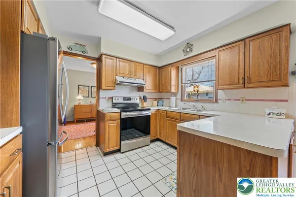 a kitchen with stainless steel appliances granite countertop a refrigerator stove and sink