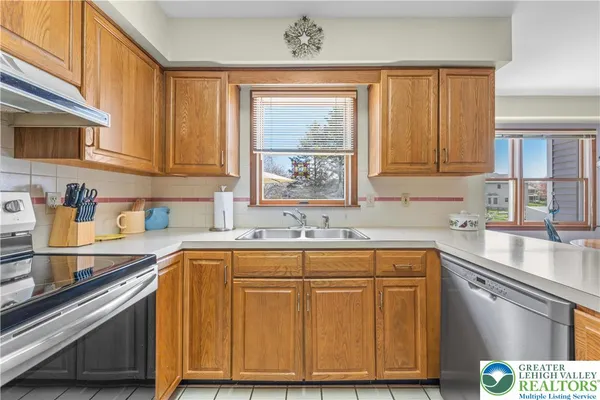 a kitchen with stainless steel appliances granite countertop a sink a stove cabinets and a window