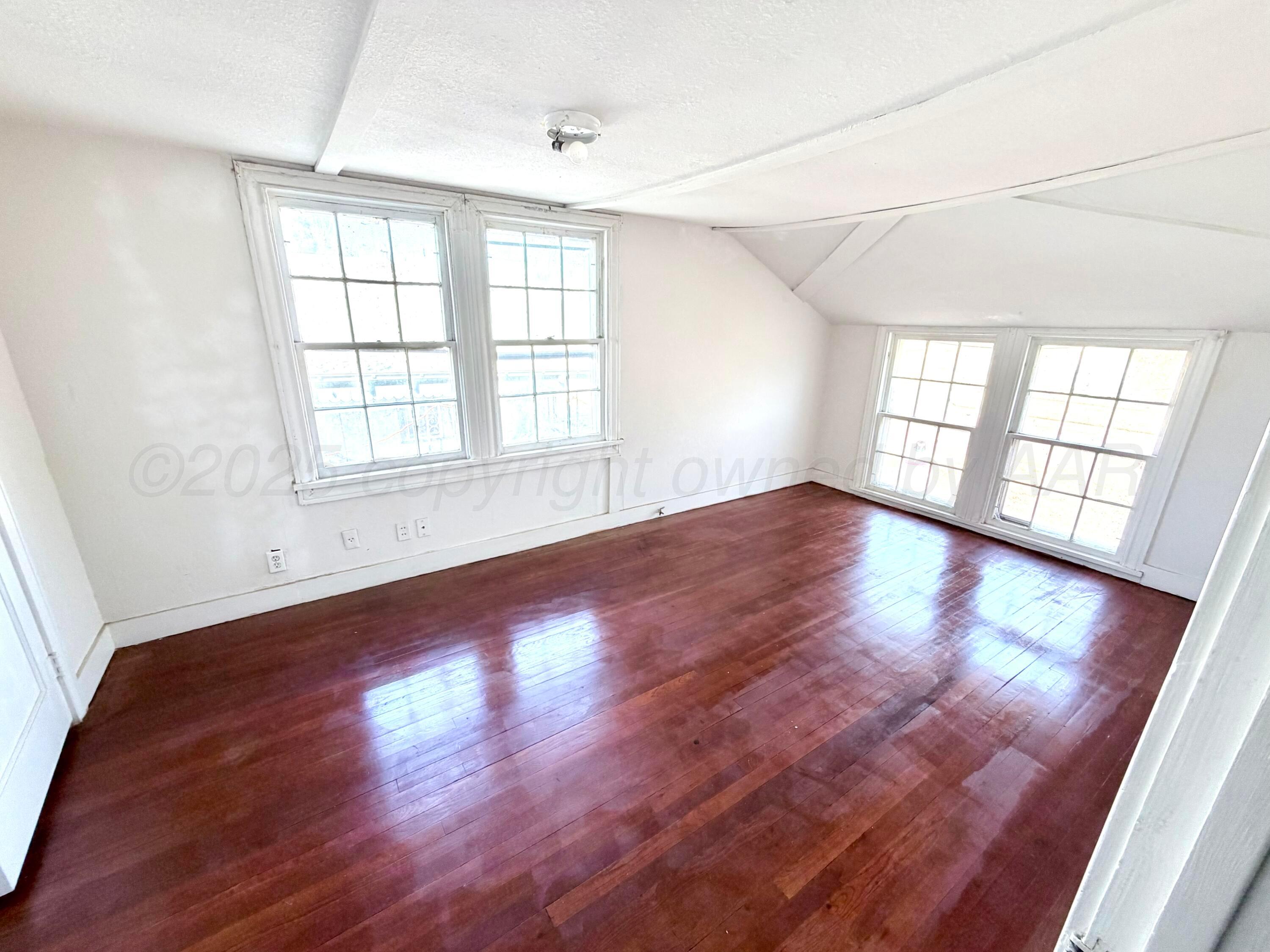1409 El Paso Street Wellington, TX 79095 - Photo 12 of 22 an empty room with wooden floor and windows