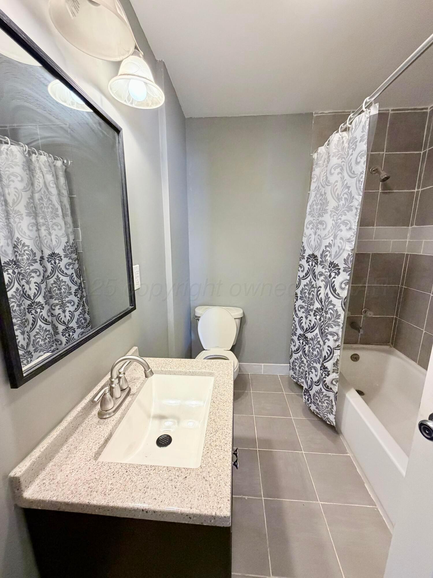 1409 El Paso Street Wellington, TX 79095 - Photo 7 of 22 a bathroom with a sink and a bathtub