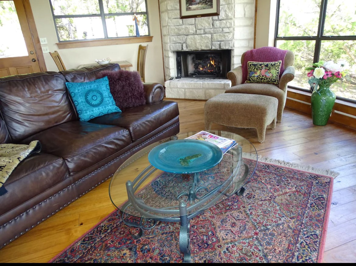 919 Little Ranches Road Wimberley, TX 78676 - Photo 7 of 13 A welcoming living area with a cozy fireplace and abundant natural light.