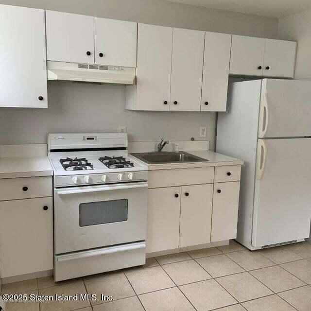 Undisclosed Address Staten Island, NY 10309 - Photo 2 of 7 a kitchen with white cabinets and white appliances