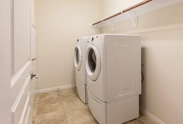 a view of kitchen with stainless steel appliances kitchen island granite countertop refrigerator and microwave