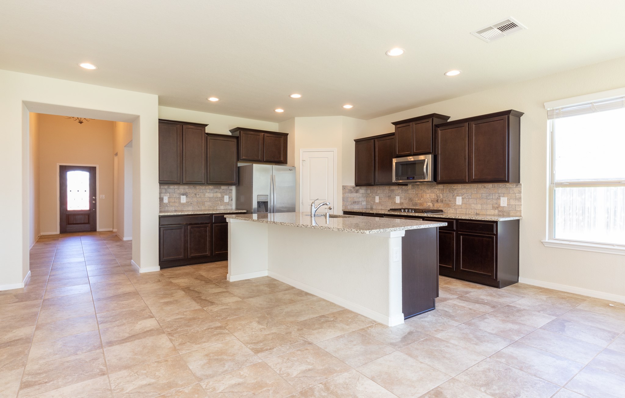 10 Log House Court Tomball, TX 77375 - Photo 19 of 50 a large kitchen with stainless steel appliances granite countertop a stove a sink and a refrigerator