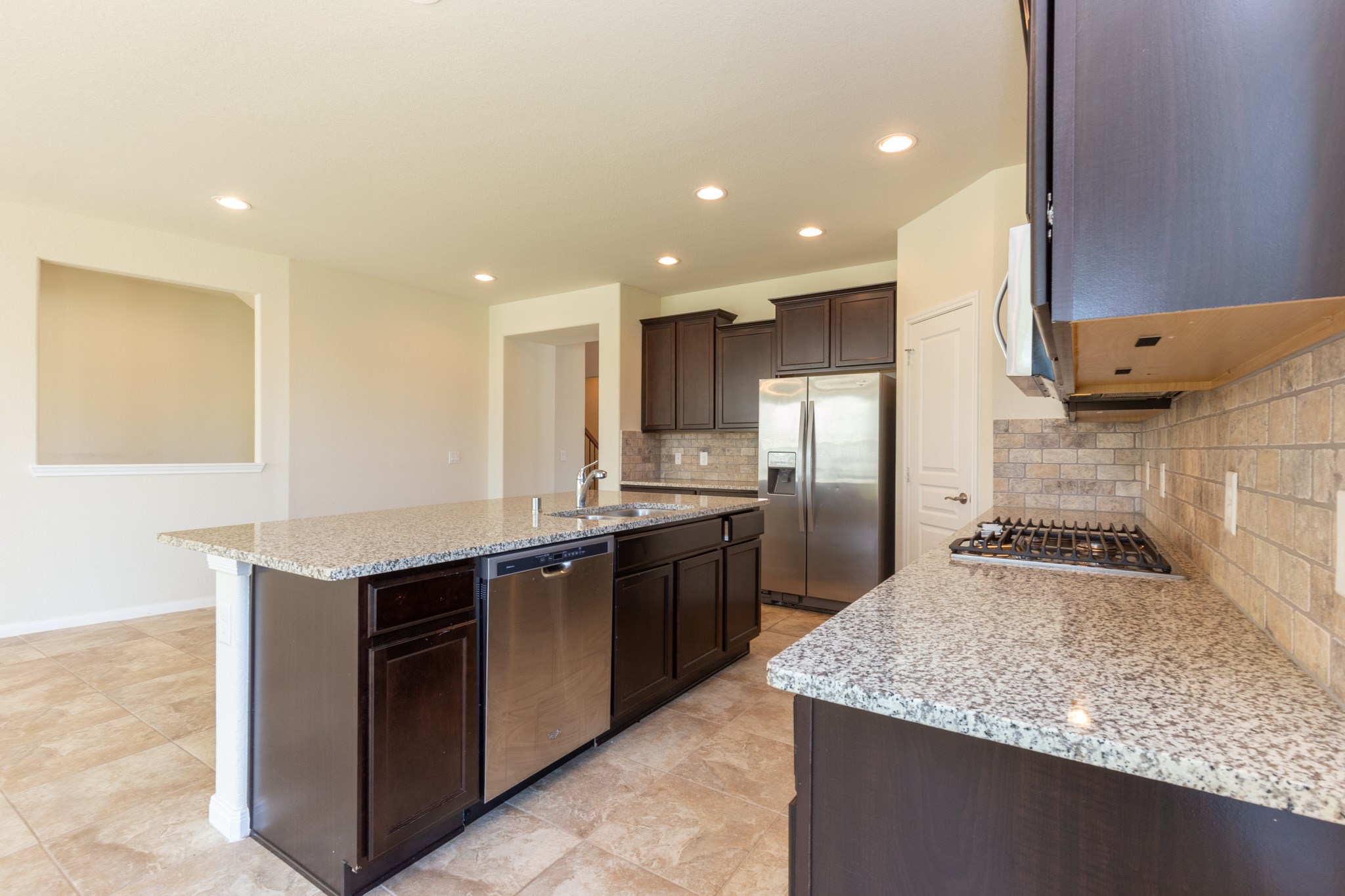 10 Log House Court Tomball, TX 77375 - Photo 21 of 50 a kitchen with stainless steel appliances granite countertop a sink stove and refrigerator