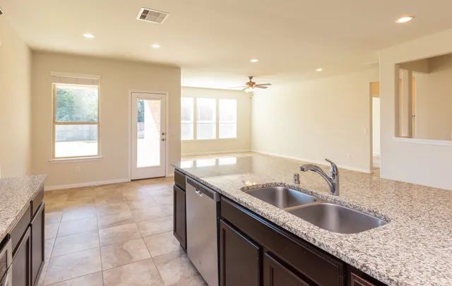 an empty room with windows and ceiling fan