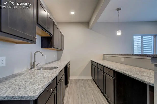 a kitchen with stainless steel appliances granite countertop a sink a oven and wooden floors