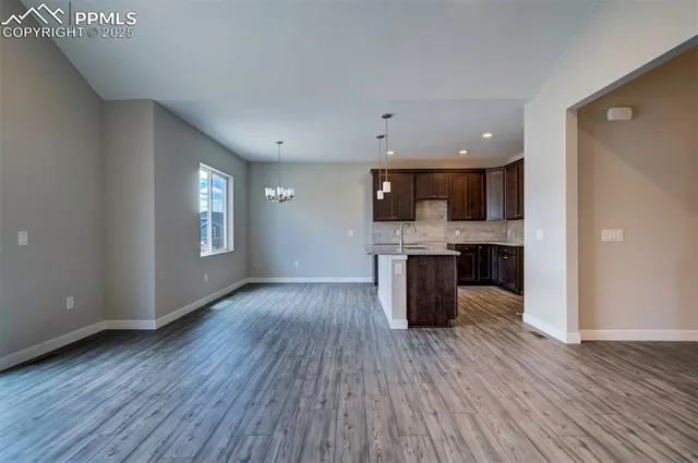 a open kitchen with kitchen island a sink dishwasher a refrigerator and wooden floor
