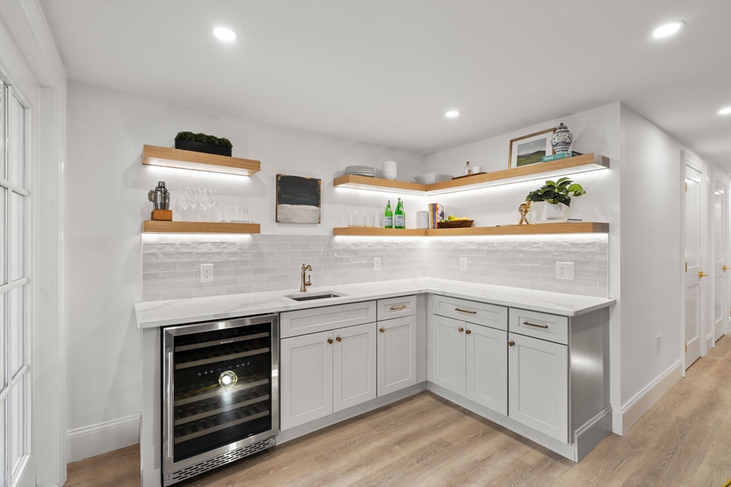 32 High Street Boston, MA 02129 - Photo 33 of 38 a kitchen with a sink dishwasher a stove and white cabinets with wooden floor