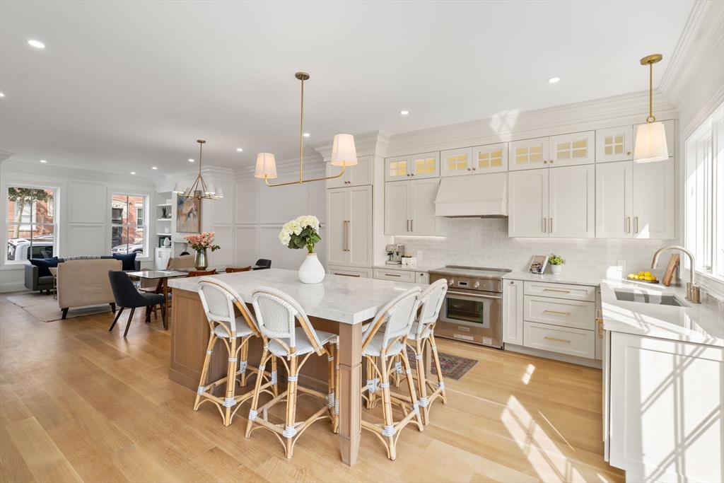 32 High Street Boston, MA 02129 - Photo 4 of 38 a kitchen with stainless steel appliances kitchen island granite countertop a table chairs sink and cabinets