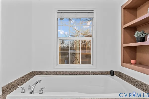 a spacious bathroom with a double vanity sink a mirror and a bathtub