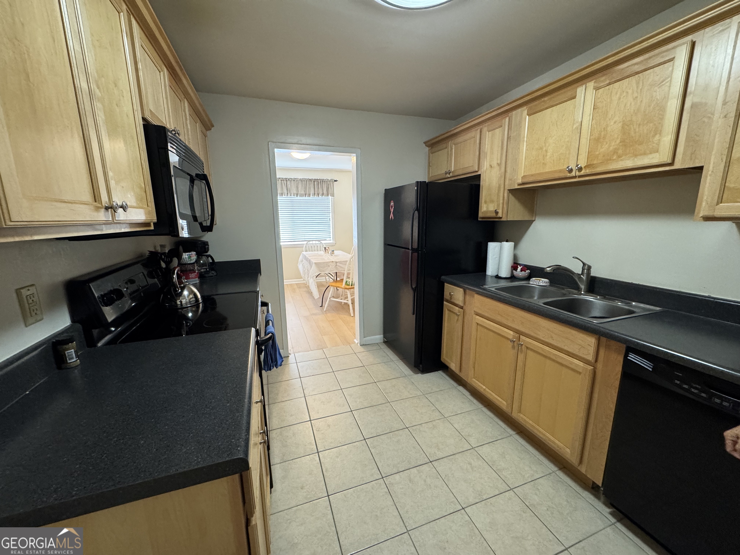 250 Little Street, Unit C210 Athens, GA 30605 - Photo 7 of 11 a kitchen with stainless steel appliances granite countertop a refrigerator and a sink