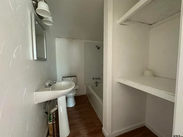 a kitchen with granite countertop a sink and wooden floors
