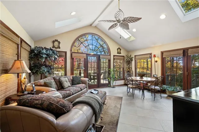 a living room with furniture a chandelier and a large window