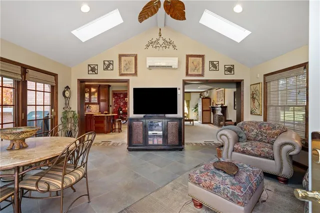 a living room with furniture a flat screen tv and a floor to ceiling window