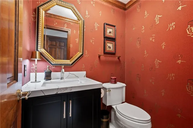 a bathroom with a toilet a sink and mirror