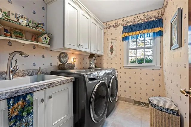 a utility room with stainless steel appliances a sink a stove and a window