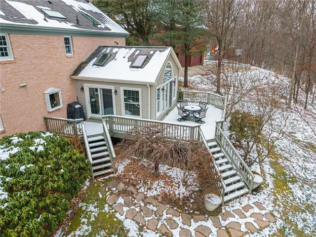 a view of a house with wooden deck and furniture