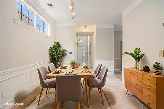 a dining room with furniture and potted plants
