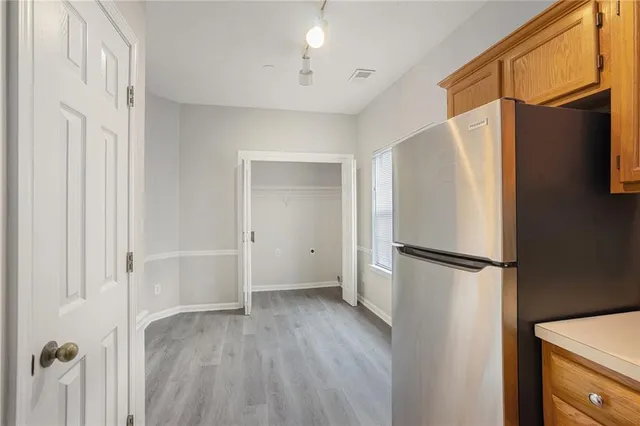 a view of a refrigerator in kitchen and wooden floor