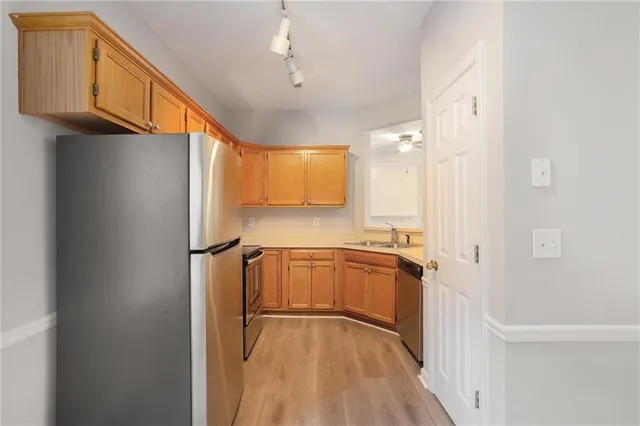 a kitchen with a refrigerator a sink and cabinets