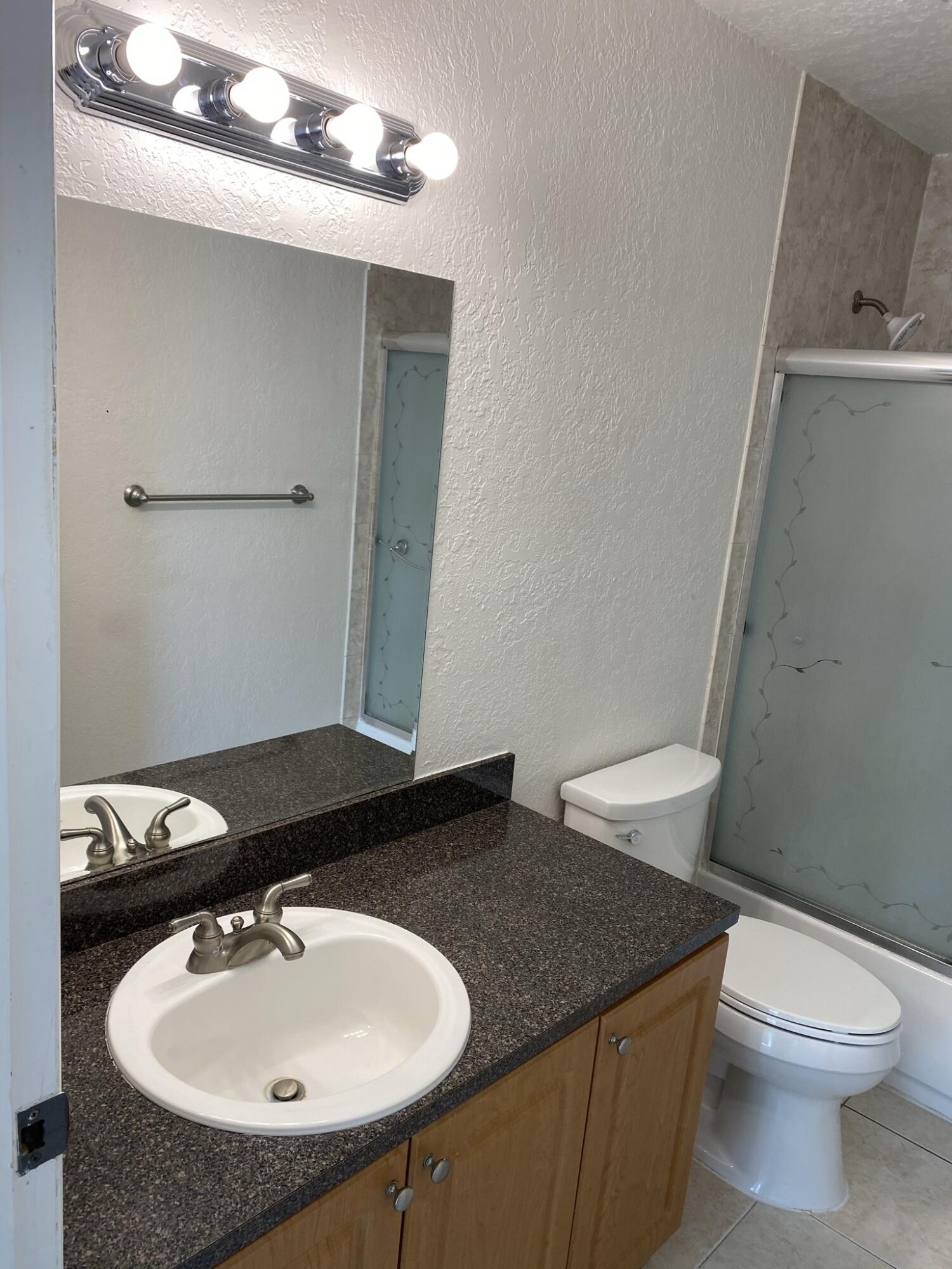 100 Nottingham Circle, Unit J Greenacres, FL 33463 - Photo 4 of 10 a bathroom with a sink and a toilet