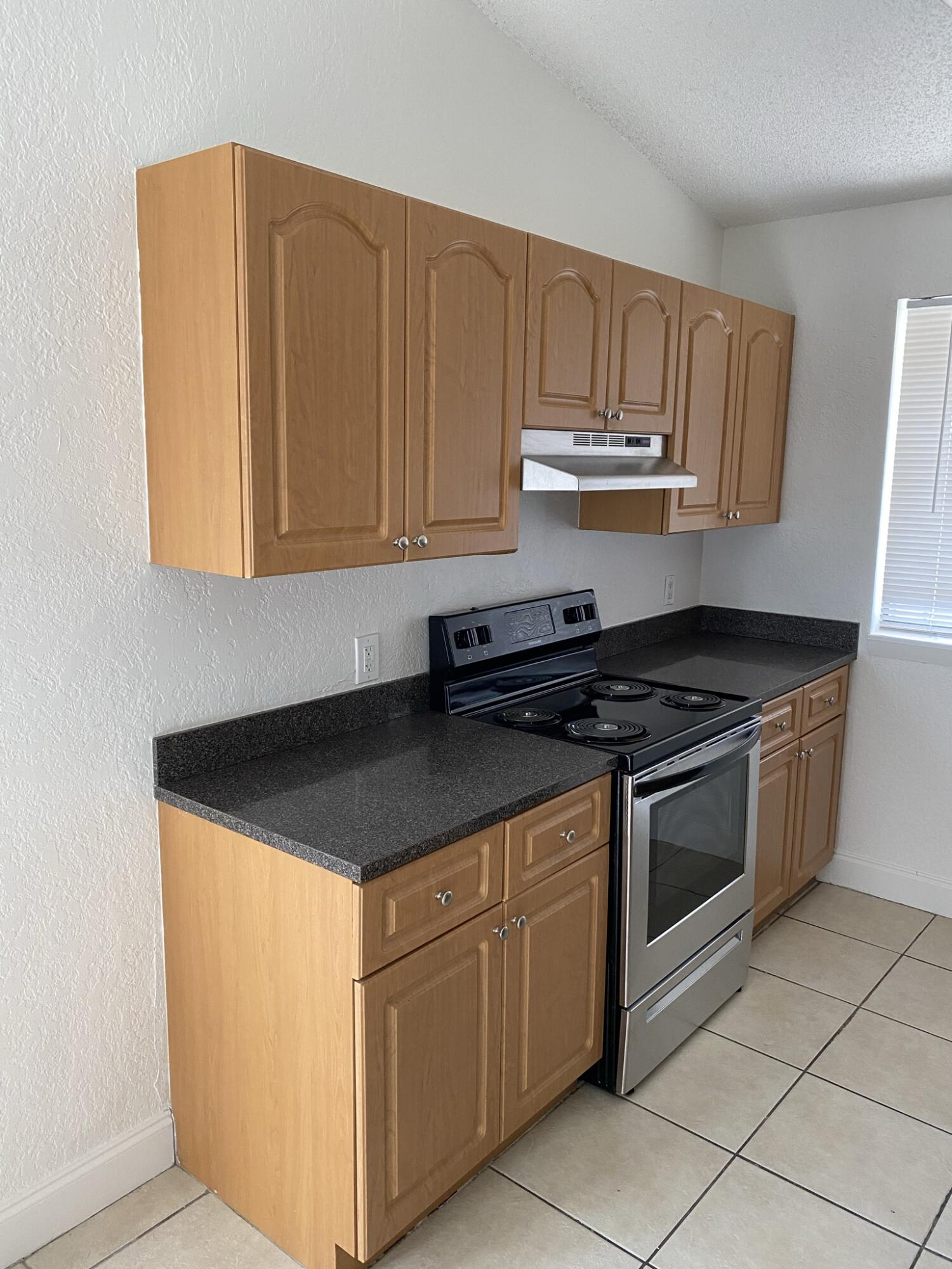 100 Nottingham Circle, Unit J Greenacres, FL 33463 - Photo 5 of 10 a kitchen with granite countertop cabinets and steel stainless steel appliances