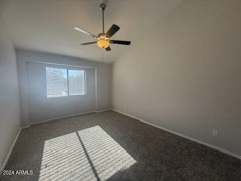 an empty room with windows and fan