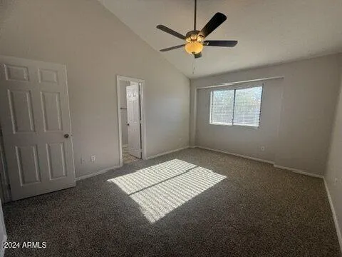 an empty room with windows and fan