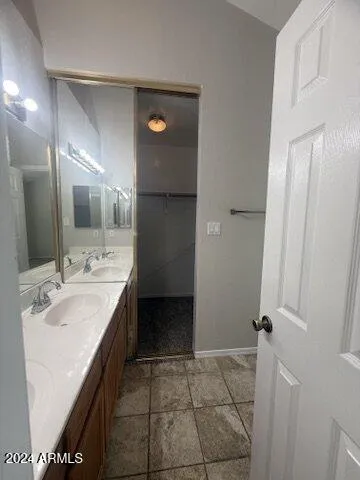 a spacious bathroom with a double vanity sink a mirror and a bathtub