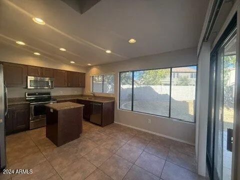a large kitchen with a large counter top and stainless steel appliances
