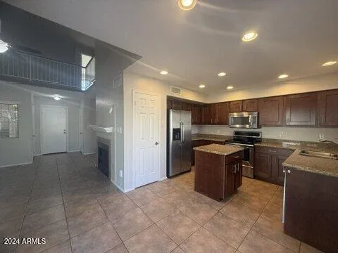 a kitchen with stainless steel appliances granite countertop a stove a sink a refrigerator and a oven