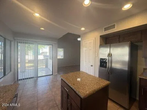 a kitchen with stainless steel appliances granite countertop a refrigerator a sink and a oven