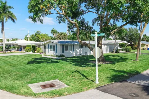 a view of house with a yard and potted plants