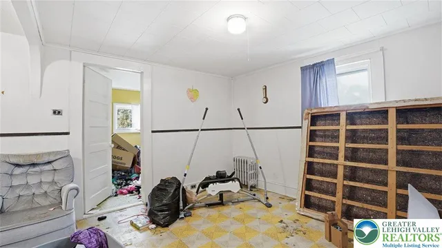 a view of a storage room with water heater and a refrigerator