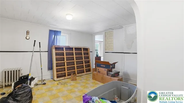 a view of a white house with a yard table and chairs