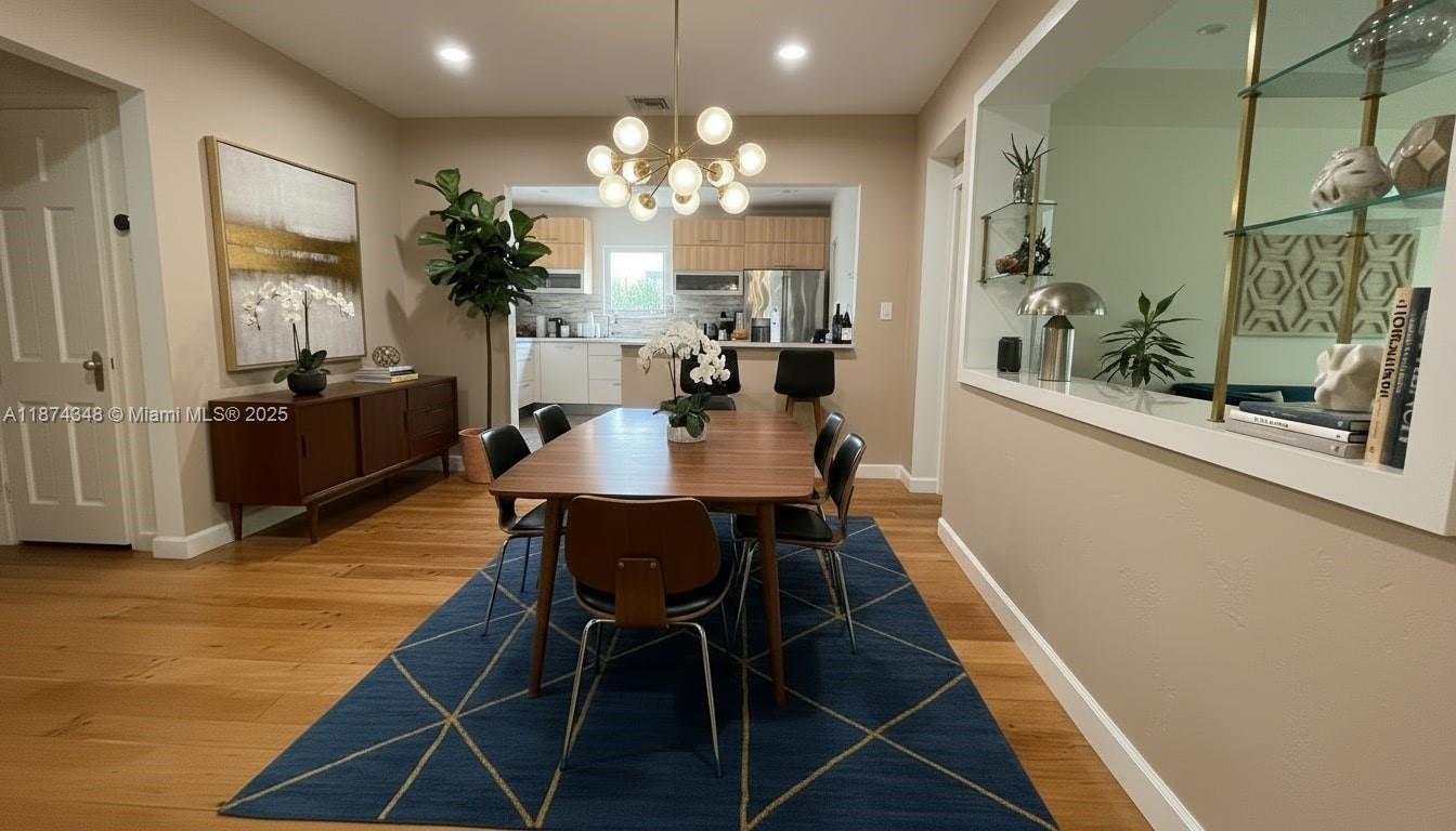 40 Southwest 30th Road Miami, FL 33129 - Photo 9 of 54 a dining room with wooden floor a chandelier a wooden table and chairs