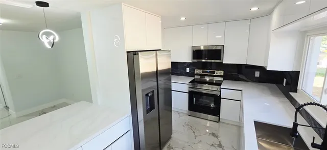 a kitchen with stainless steel appliances granite countertop a stove and a refrigerator