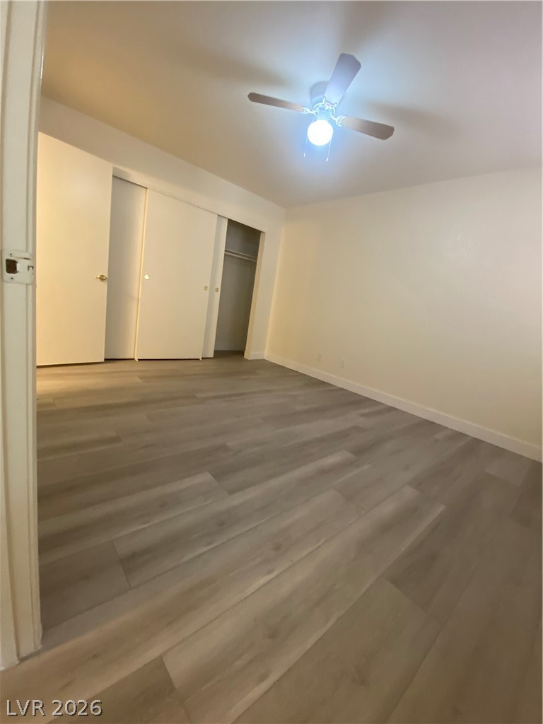7570 West Flamingo Road, Unit 125 Las Vegas, NV 89147 - Photo 7 of 29 Unfurnished bedroom featuring ceiling fan, wood finished floors, and a closet